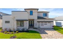 Beautiful home featuring modern architecture, a two-car garage, stone accents, and well-manicured landscaping at 8421 Golden Beach Ct, Parrish, FL 34219