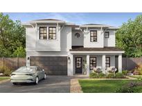 Charming two-story home boasts white siding, a modern garage door, and a cozy covered front porch at 1009 W Ohio Ave, Tampa, FL 33603