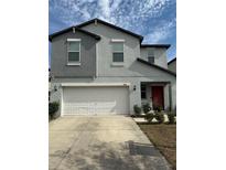 Charming two-story home showcasing a well-manicured front yard, a spacious two-car garage, and an inviting red front door at 13456 Marble Sands Ct, Hudson, FL 34669