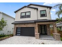 Beautiful two-story home features a brick and stucco exterior with a black garage door and complementary door at 1046 Bass Blvd, Dunedin, FL 34698