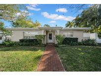 Charming single-story home with a brick walkway, mature landscaping, and a welcoming entrance at 216 21St Ne Ave, St Petersburg, FL 33704
