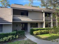 Charming condo featuring a well-maintained exterior, a walkway, beautiful landscaping and a second story balcony at 103 Old Mill Pond Rd, Palm Harbor, FL 34683