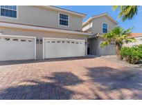 Inviting home with brick driveway, three-car garage, and well-maintained landscaping at 1264 Riserva Ln, Palm Harbor, FL 34683