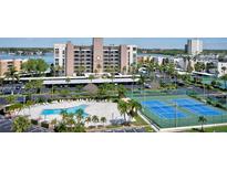Scenic community view showcasing pool, tennis courts, parking, and waterfront access at 7600 Sun Island S Dr # 804, South Pasadena, FL 33707