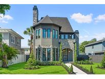 Charming two-story home showcasing stone accents, a well-manicured lawn, and lush landscaping at 807 W Park Ave, Tampa, FL 33602
