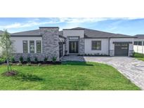 Beautiful single Gathering home featuring a modern exterior with brick driveway, lawn and minimalist landscaping at 8347 Golden Beach Ct, Parrish, FL 34219