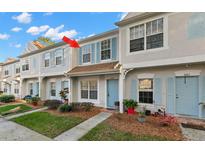 Charming townhome featuring light blue shutters, a light blue door, and a well-manicured lawn at 8615 Hunters Key Cir, Tampa, FL 33647
