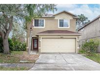 Charming two-story home features a two-car garage, landscaped yard, and mature trees in a suburban neighborhood at 10815 Wrigley Ct, Riverview, FL 33579