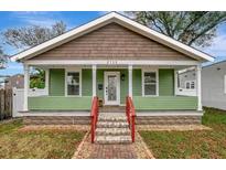 Charming home with green exterior, inviting front porch, and well-manicured lawn offering curb appeal at 2715 14Th N Ave, St Petersburg, FL 33713