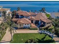 Expansive waterfront home featuring lush landscaping, tile roof, and a paver driveway leading to stunning bay views at 3901 Bayshore Ne Blvd, St Petersburg, FL 33703