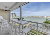 Relaxing balcony featuring a bar-height table with seating, a ceiling fan, and stunning views of the water at 6093 Bahia Del Mar Cir # 375, St Petersburg, FL 33715