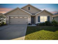 Charming single-story home featuring a two-car garage, shutters, and a well-maintained lawn at 12143 Kingsley Trl, Parrish, FL 34219