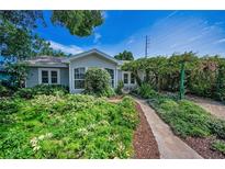 Charming home featuring lush, mature landscaping and a welcoming stone pathway to the front door at 546 Orangewood Dr, Dunedin, FL 34698