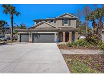 Inviting home exterior showcasing a three-car garage, stone accents, lush landscaping, and a brick paver walkway at 5701 S Macdill Ave, Tampa, FL 33611