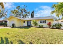 Charming single-story home with a well-maintained lawn and colorful landscaping, offering great curb appeal at 2589 Redwood Cir, Clearwater, FL 33763