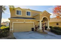 Charming home boasting an attached garage, manicured shrubs, and an arched entryway at 8999 Founders Cir, Palmetto, FL 34221