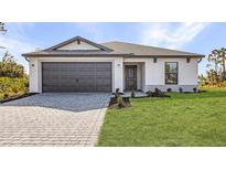 Charming single-story home showcasing a well-manicured lawn and a gray two-car garage at 4294 Danbury St, North Port, FL 34286
