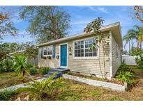 Charming single-story home featuring a blue front door, landscaped yard, and manicured flower beds at 5053 3Rd N Ave, St Petersburg, FL 33710