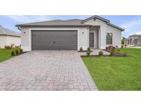 Attractive single-story home with a two-car garage, brick paver driveway, and well manicured landscaping at 5710 Humkey St, North Port, FL 34291