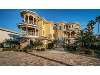 Stunning multi-story home featuring stone accents, balconies and lush landscaping at 335 Bath Club S Blvd, North Redington Beach, FL 33708