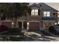 Charming townhome featuring a private garage, welcoming entrance, and nicely landscaped front yard at 26614 Castleview Way, Wesley Chapel, FL 33544