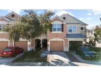 Charming two-story townhome with a one-car garage, landscaped front yard, and welcoming curb appeal at 26614 Castleview Way, Wesley Chapel, FL 33544