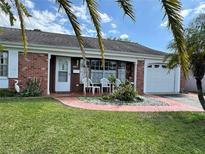 Charming single-story brick home with a well-maintained front yard and a cozy seating area on the porch at 3722 Haven Dr, New Port Richey, FL 34652