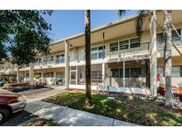 Beige two-story condo building featuring screened patios and second-story decorative railings at 4154 57Th N St # 173, Kenneth City, FL 33709