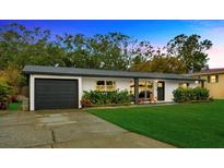 Charming one-story home with a well-manicured lawn, attached garage, and lovely landscaping at 4519 S Hesperides St, Tampa, FL 33611