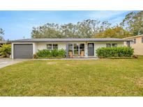 Charming single-story home featuring a well-manicured lawn and inviting front entrance with outdoor seating at 4519 S Hesperides St, Tampa, FL 33611