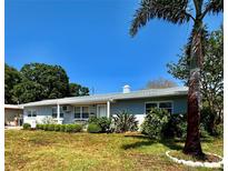 Charming single-story home featuring a well-manicured front yard with lush landscaping and a clear blue sky backdrop at 6623 16Th N St, St Petersburg, FL 33704