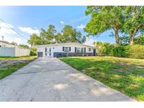 Charming single-story home with a well-maintained lawn and spacious driveway at 8703 Driftwood Dr, Tampa, FL 33615