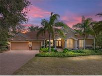 Charming home featuring a barrel tile roof, meticulously manicured landscaping and a three car garage at 12700 Grand Traverse Dr, Dade City, FL 33525