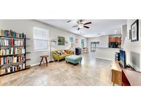 Bright living room boasts large windows and a ceiling fan, complemented by stylish, comfortable furniture at 3818 Cat Mint St, Tampa, FL 33619