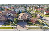 An inviting house boasts a tile roof, brick driveway, and well-maintained landscaping in a desirable neighborhood at 2564 Grand Cypress Blvd, Palm Harbor, FL 34684