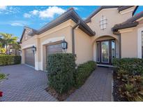Charming home featuring a two-car garage and a beautifully landscaped walkway leading to the front door at 2564 Grand Cypress Blvd, Palm Harbor, FL 34684