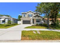 Charming two-story home with a well-manicured lawn, dark gray garage door, and inviting front porch at 3218 21St N St, St Petersburg, FL 33713