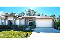 Charming single-story home featuring a well-maintained lawn, two-car garage, and beautifully landscaped front yard at 11440 Baronwood Ct, Hudson, FL 34667