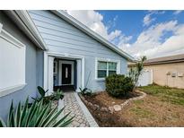 Charming single-story home featuring a covered entry, decorative columns, and inviting landscaping at 12245 68Th St, Largo, FL 33773