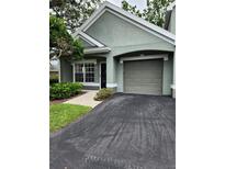 Charming one-story home featuring a gray garage and well-maintained landscaping at 3653 Kings Rd # 101, Palm Harbor, FL 34685