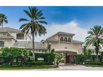 Exterior view of building 501 featuring an entrance portico, lush greenery, and a neatly landscaped entrance at 501 Knights Run Ave # 2119, Tampa, FL 33602