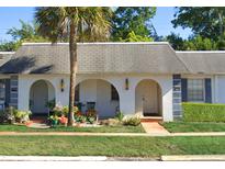 Charming home featuring an arched entryway, garden area, and mature landscaping at 4242 Redcliff Pl # C, New Port Richey, FL 34652