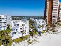 Beautiful beachfront condos with white exteriors, balconies, and palm trees offering stunning ocean views at 17960 Gulf Blvd # 103, Redington Shores, FL 33708