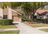 Exterior shot of the townhome with a well-maintained lawn and driveway at 3985 Mermoor Dr, Palm Harbor, FL 34685