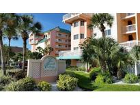 Beautiful exterior shot of The Beach Cottage condo building with lush landscaping and palm trees at 18400 Gulf Blvd # 1505, Indian Shores, FL 33785