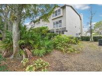 A beautiful view of the exterior of the home, lush landscape, and screened-in porch in a suburban setting at 2794 Countryside Blvd # 1, Clearwater, FL 33761