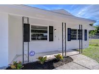 Inviting front porch with wrought iron accents and modern security system, enhancing curb appeal at 5836 8Th St, Zephyrhills, FL 33542