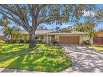 Charming one-story home with a well-manicured lawn, mature trees, and a spacious driveway leading to a two-car garage at 970 45Th Ne Ave, St Petersburg, FL 33703