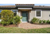 Inviting front entrance with a stylish teal door, brick walkway, and lush landscaping at 11125 Callisia Dr, Odessa, FL 33556