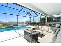 Relaxing screened-in lanai featuring a gorgeous pool, outdoor seating area, and tranquil lake views at 12425 Glenridge Ln, Parrish, FL 34219